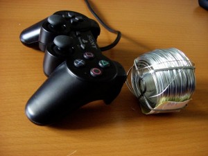Playstation 2:n peliohjain ja rulla teräslankaa