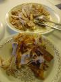 Broilerin koipi jaettuna kahdelle lautaselle; etummaisella lautasella ovat luut ja nahka, takimmaisella liha