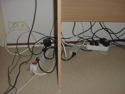 Tietokoneen sähköjohtoja tietokonepöydän alla