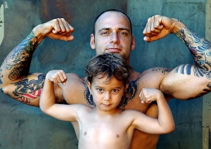 Tatuoitu voimamies ja poika pullistavat hauiksia