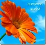Oranssi kehäkukan kukinto, oikeassa yläkulmassa teksti sunshine award